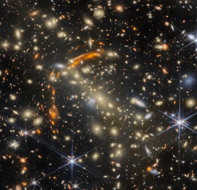 Space - Gravitational lens reveals rare duplicated galaxies in cosmic cluster